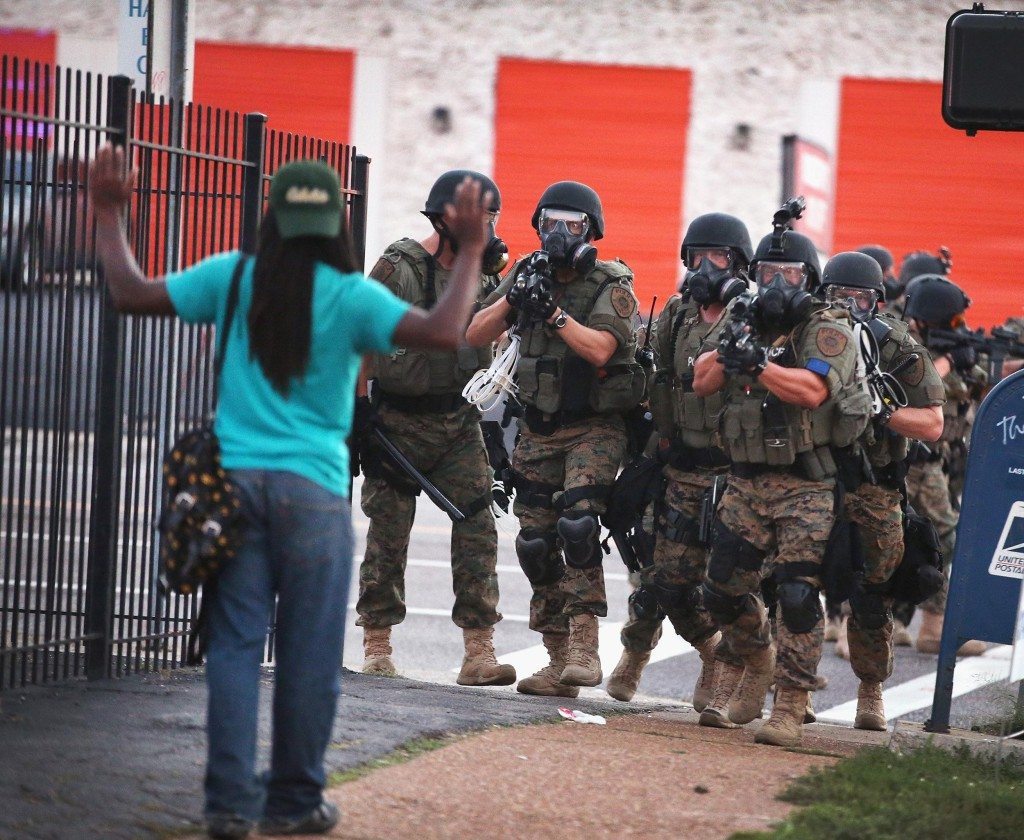 An Armed Police Unit challenges a passerby in Ferguson.